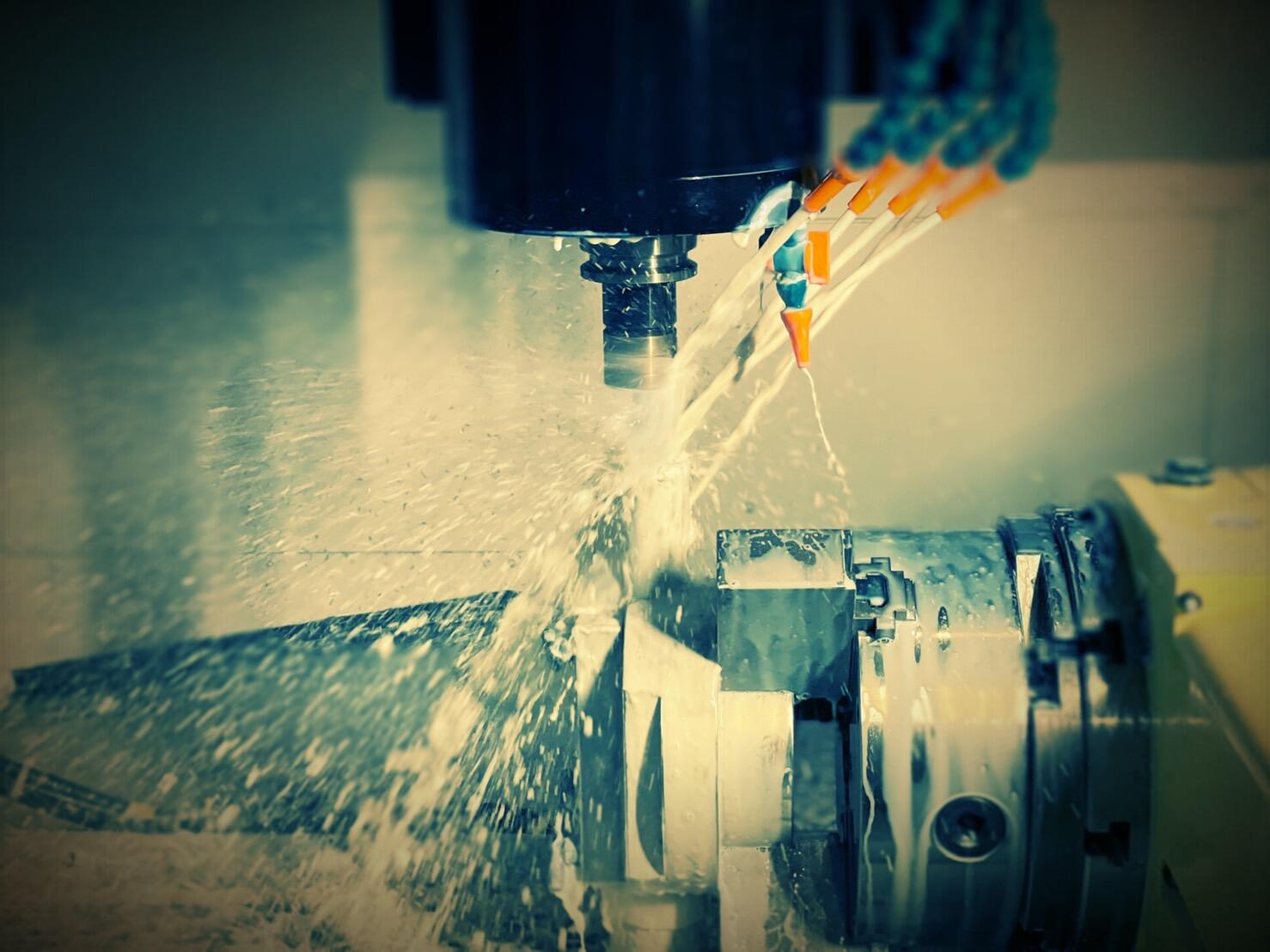 A close-up, high-contrast shot of a CNC machine performing a cutting operation.